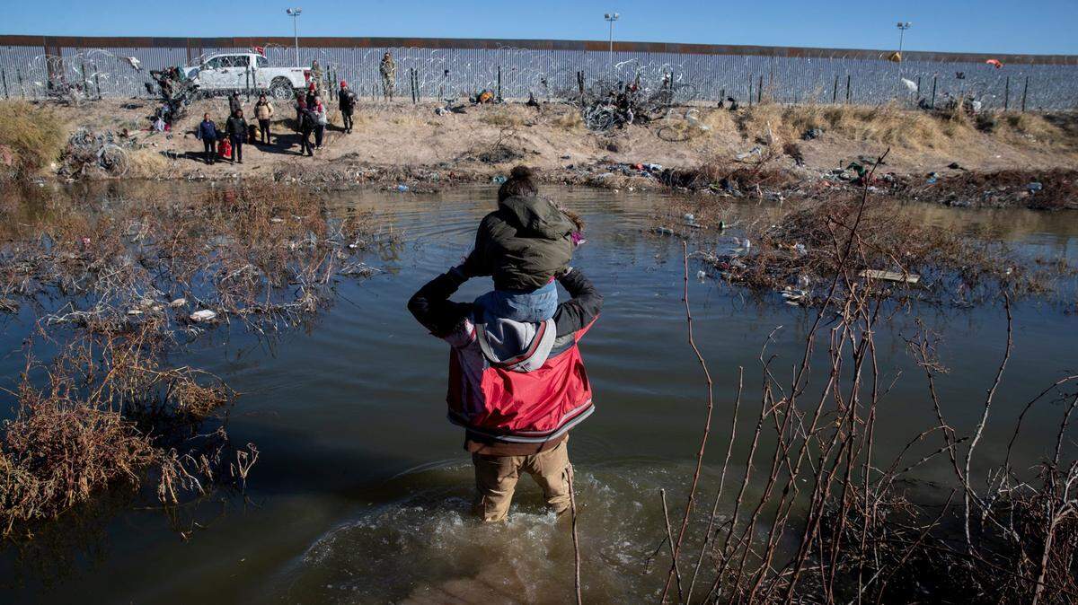 Un padre y su hija intentan cruzar el rio Bravo desde Ciudad Juárez hasta el Paso, Texas, con la esperanza de solicitar asilo, el 6 de enero de 2024.