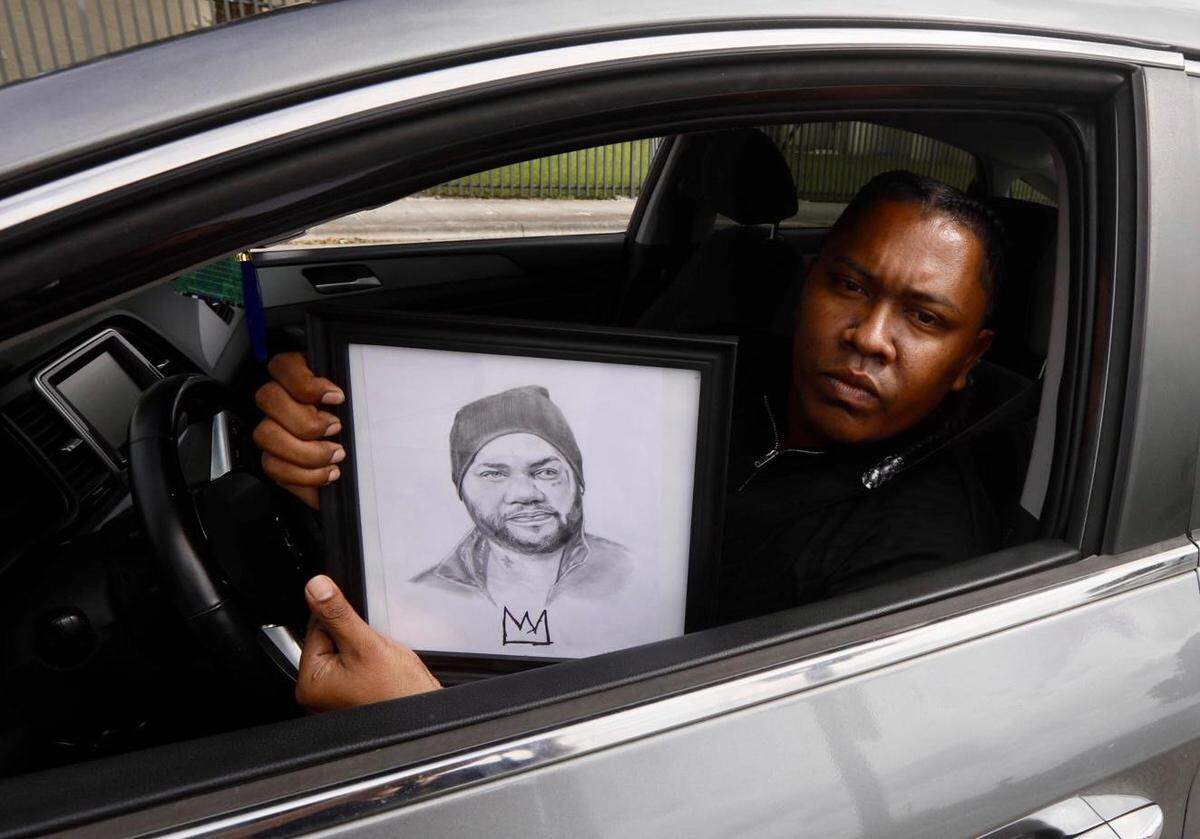 Hialeah, Florida, October19, 2024 - Jeffrey Jarquin holds a framed drawing of El Taiger outside the San Lázaro Catholic Church in Hialeah where a funeral mass was held for Jose Manuel Carvajal, El Taiger.