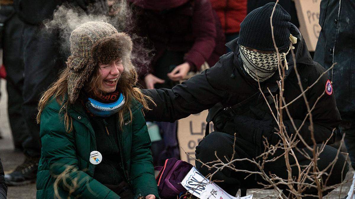 Una mujer llora ante un monumento improvisado en la zona donde Alex Pretti, de 37 años, fue abatido a tiros por agentes federales de inmigración en Minneapolis, Minnesota, el sábado 24 de enero de 2026.
