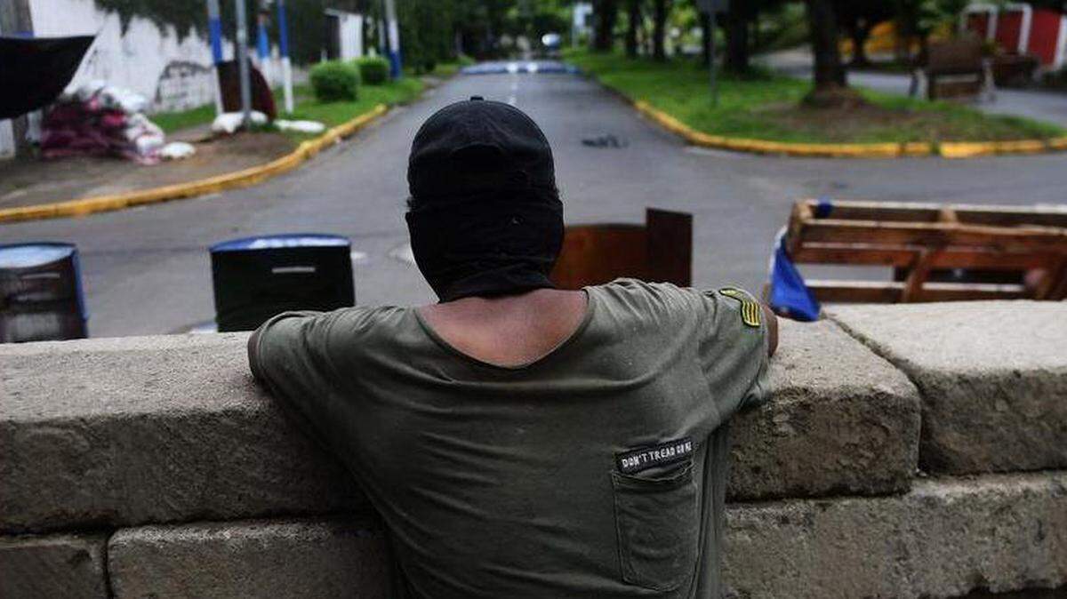Un estudiante vigila una barricada frente a los continuos ataques de la policía antidisturbios y miembros de la Juventud Sandinista, en los alrededores de la Universidad Nacional Autónoma de Nicaragua (UNAN), en Managua el 23 de junio de 2018.