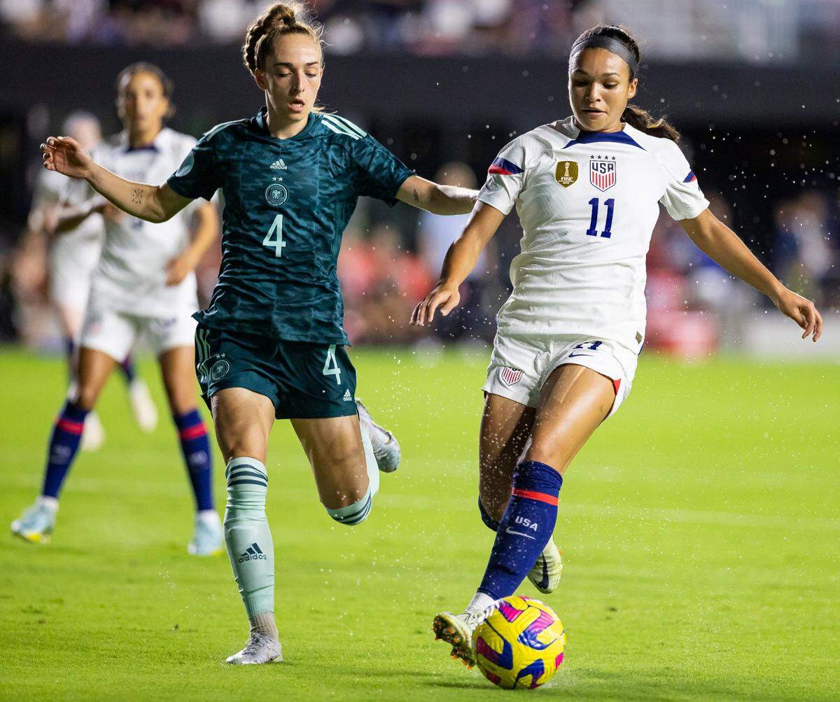 La jugadora de Estados Unidos Sophia Smith (der.) conduce la pelota ante la marca de Sophia Kleinherne, de Alemania, en la primera mitad del partido amistoso celebrado el 10 de noviembre de 2022 en el DRV PNK Stadium en Fort Lauderdale, Florida.