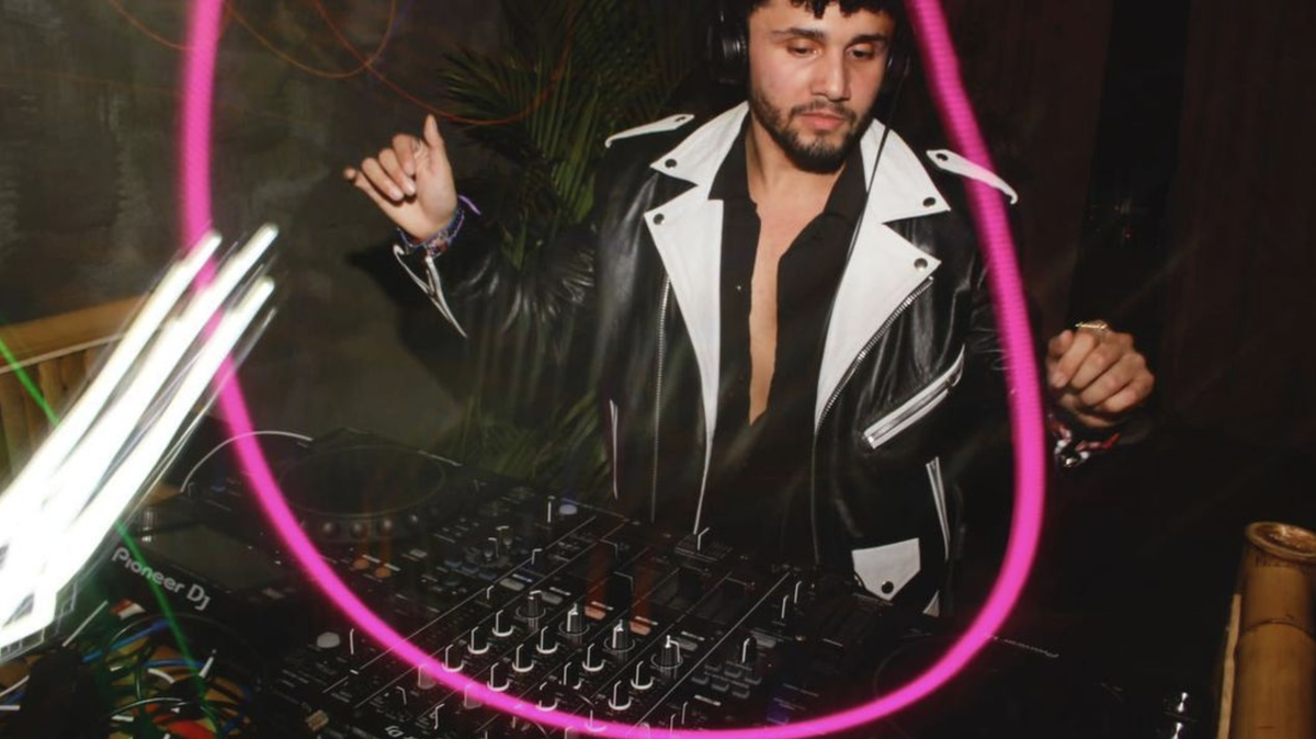 Miguel Clark se ve frente de una mesa de DJ. Elementos de luz estilísticos decoran la imagen.