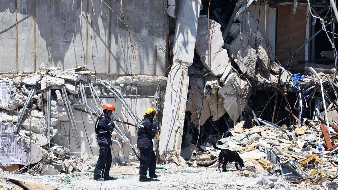 Search and rescue personnel search for survivors through the rubble with their dogs at the Champlain Towers South in Surfside, Florida, Sunday, June 27, 2021. The condo building partially collapsed on Thursday, June 24.