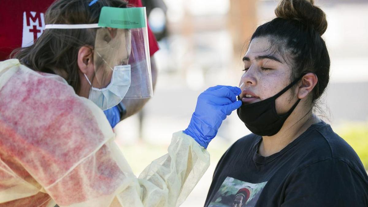 Leiana Smith, una enfermera registrada, a la izquierda, toma una muestra de Lisset Jiménez en un lugar de prueba de COVID-19 el jueves 16 de julio de 2020, en el estacionamiento de 2001 W. Lincoln Ave. en Yakima, Washington.