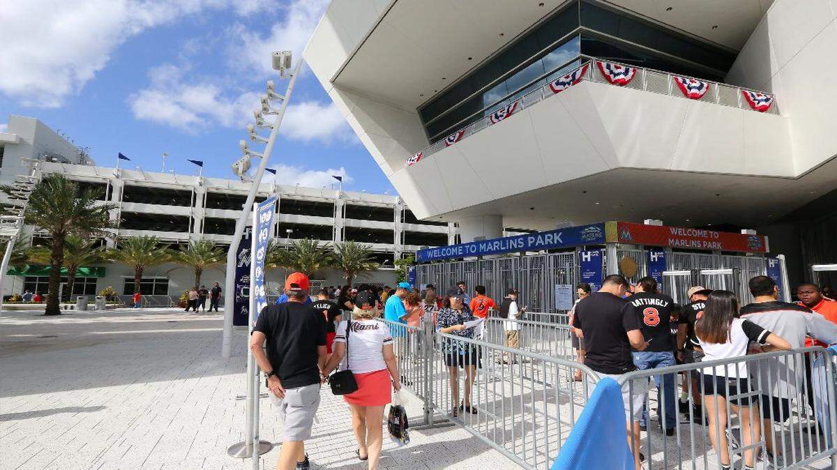 Un grupo de personas hace cola para entrar al Marlins Park para presenciar el partido de apertura en casa ante los Bravos de Atlanta, el 11 de abril del 2017 en Miami.