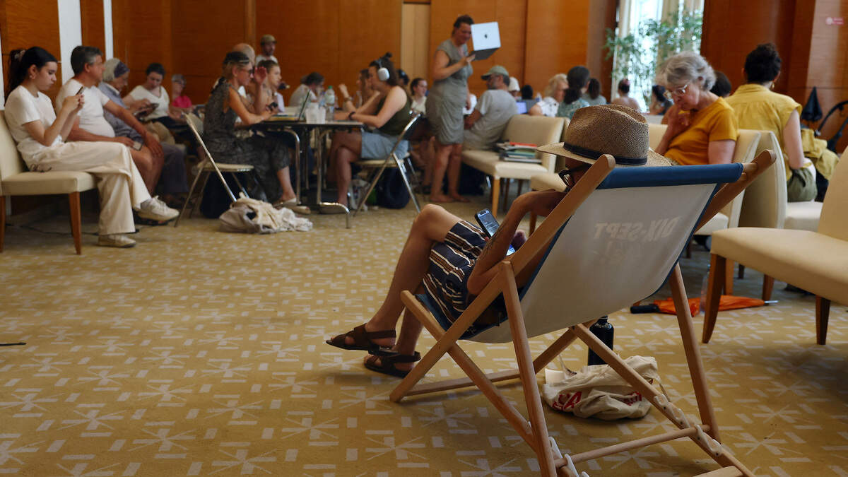 Un grupo de personas se reúne en una sala con aire acondicionado abierta al público en el interior del ayuntamiento del distrito 17, a medida que suben las temperaturas en París, durante una ola de calor que afecta a la mayor parte de Francia, el jueves 25 de junio de 2026.