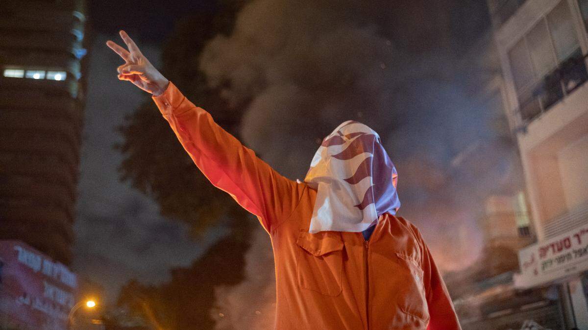 Un manifestante hace el signo de la victoria mientras familiares de los rehenes y simpatizantes participan en una manifestación para exigir la liberación de todos los rehenes, en el marco de la conmemoración israelí de los 600 días de su secuestro, frente a la sede del partido Likud, el 28 de mayo del 2025, Tel Aviv, Israel.