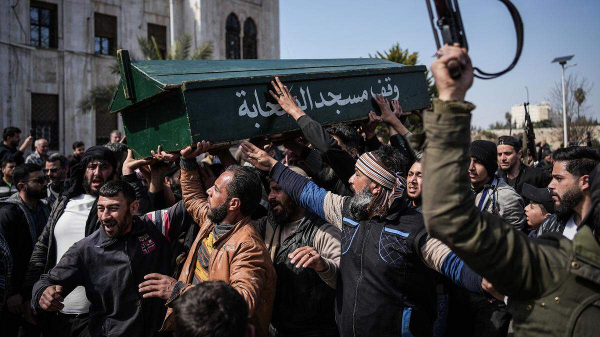 Civiles y soldados transportan el féretro de un soldado miembro de las fuerzas de seguridad de Siria, que fue abatido por tropas leales al depuesto dictador Bashar Assad, el domingo 9 de marzo de 2025, en Latakia, Siria.