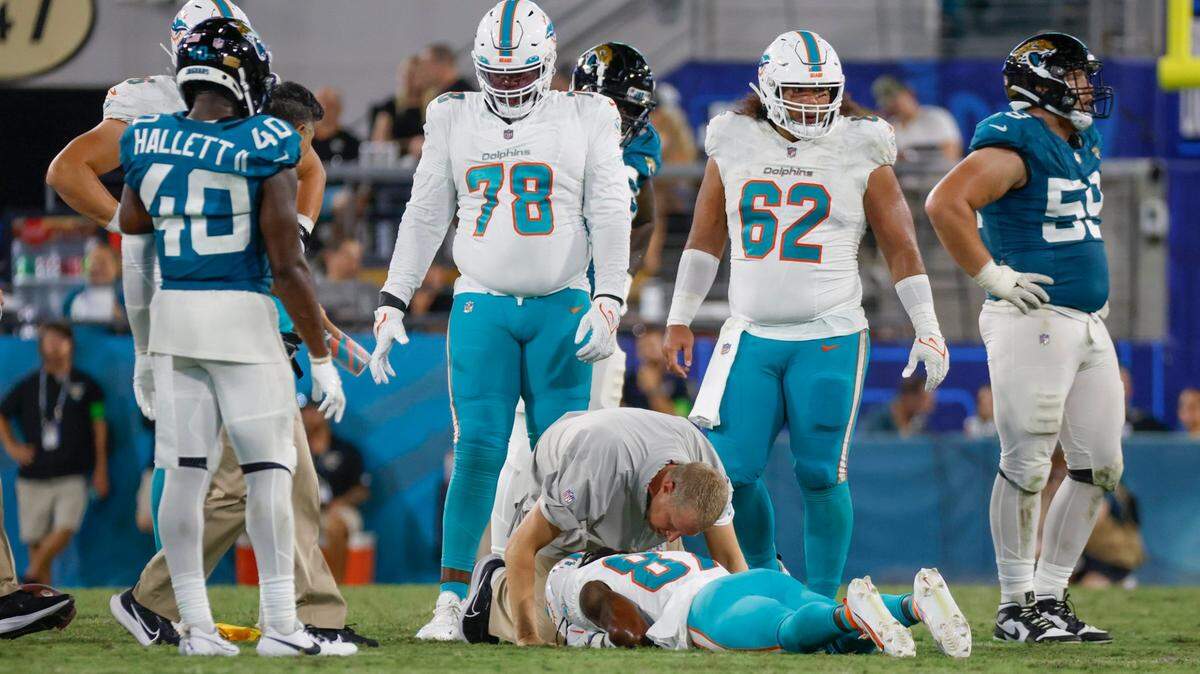 El entrenador físico de los Dolphins Kyle Johnston chequea al wide receiver Daewood Davis después de lesionarse en el partido de pretemporada ante los Jaguars, celebrado el 26 de agosto de 2023 en Jacksonville, Florida.