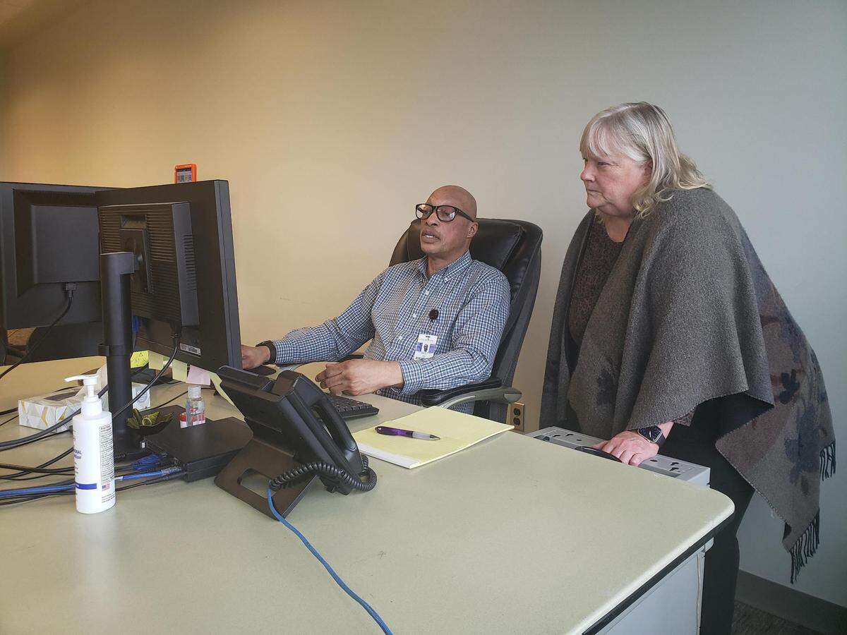 El 4 de mayo de 2023, Jody White (izq.) y Grace Burke, de Morton Comprehensive Health Services en Tulsa, Oklahoma, revisan una lista de pacientes del centro de salud cuya elegibilidad para Medicaid estaba pendiente de revisión ese mes. White había pasado la mañana llamando a los pacientes de la lista para asegurarse de que estuvieran al tanto del proceso y ofrecerles su ayuda.