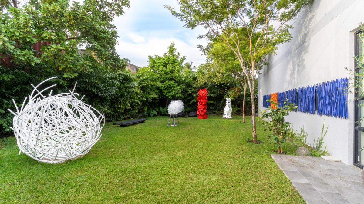 Esculturas de Ricardo Cárdenas en el patio de la galería. En la pared ‘Paisaje abstracto II’, 2023, aluminio pintado, 39 3/8 x 63 3/8 x 3 7/8 pulgadas.