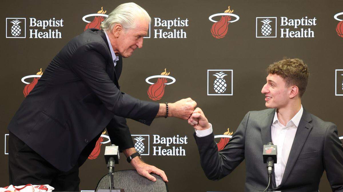 El presidente del Heat Pat Riley (izq.) choca su puño con el de Nikola Jovic en la presentación oficial del prospecto escogido en el Draft de la NBA, celebrada el 27 de junio de 2022 en Miami.