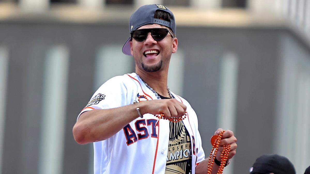 El primera base de los Astros de Houston Yuli Gurriel (10) lanza cuentas a la multitud encima de un vehículo de desfile durante el Desfile del Campeonato de los Astros de Houston en Houston.
