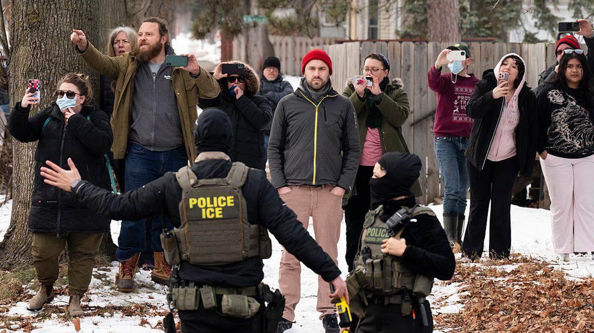 Varios observadores graban en vídeo a agentes del ICE mientras establecen un perímetro de seguridad después de que uno de sus vehículos sufriera un pinchazo en Penn Avenue, el jueves 5 de febrero de 2026 en Minneapolis, Minnesota.