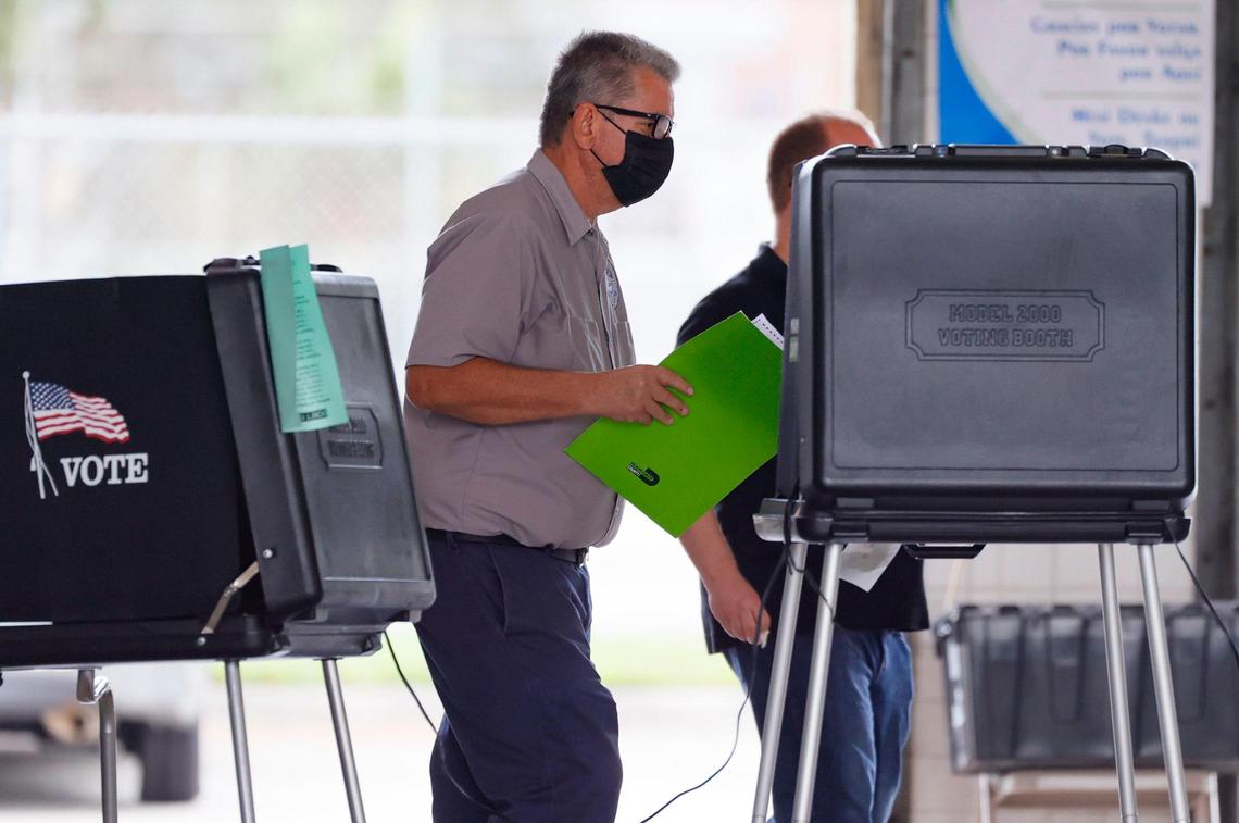 Un empleado del Departamento de Elecciones asiste a un elector que está votando en el precinto ubicado en la estación de bomberos #5 en Hialeah, el 2 de noviembre.