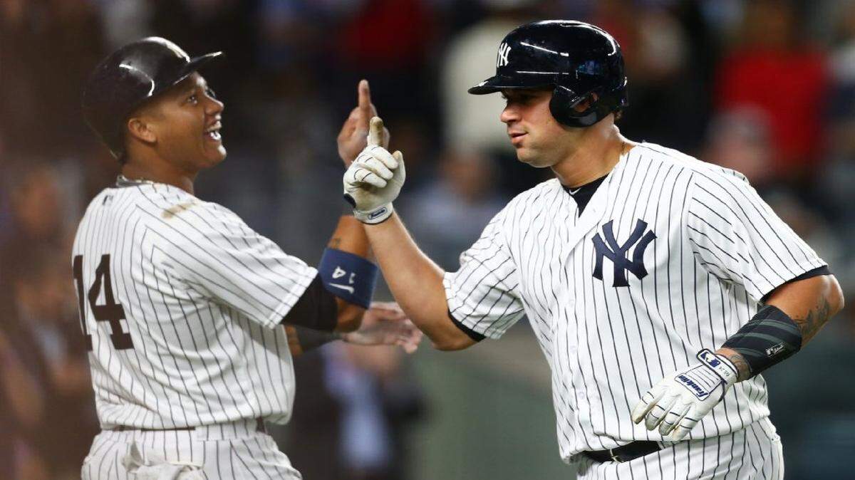 El receptor de los Yankees Gary Sánchez (der.) celebra con su compañero de equipo Starlin Castro  después de batear un jonrón de dos carreras en la quinta entrada contra los Medias Rojas de Boston, el 8 de junio de 2017.