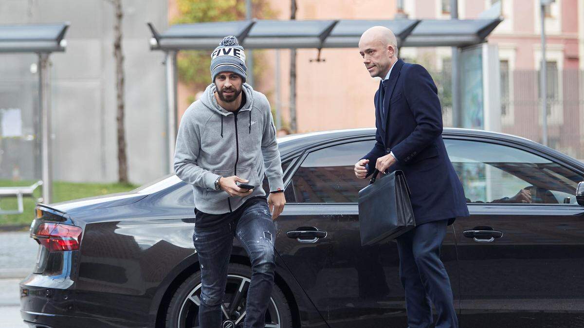 El futbolista del Barcelona Gerard Piqué, acompañado de su abogado, David Velazquez (der.), a su llegada a la Ciudad de la Justicia de Barcelona, donde declaró ante el juzgado de instrucción 27 por un delito contra la seguridad del tráfico por conducir sin puntos en el carné.