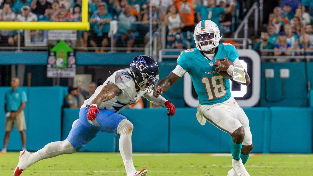 El quarterback de los Dolphins Tyler Huntley (der.) trata de pasar la marca del safety de los Titans de Tennessee Amani Hooker, en la primera mitad del partido de la NFL celebrado el 30 de septiembre de 2024 en el Hard Rock Stadium en Miami Gardens, Florida.