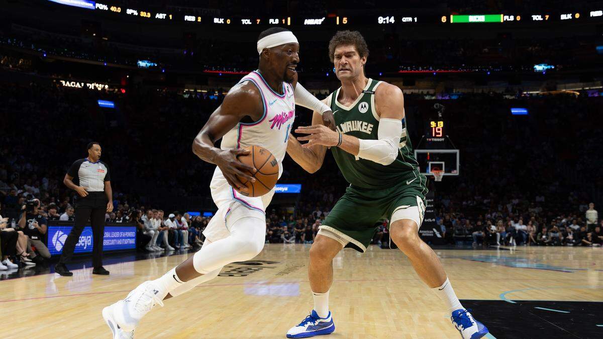 Bam Adebayo (13), del Heat, conduce hacia la canasta mientras es defendido por el pívot de los Milwaukee Bucks, Brook Lopez (11), durante la primera mitad de su juego en el Kaseya Center en Miami, Florida, el viernes 14 de marzo de 2025.