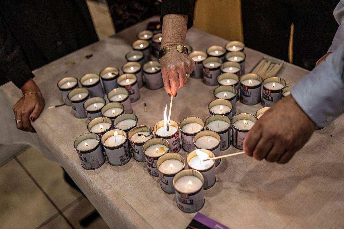 Israelis light candles laid out in the shape of the Star of David, the day after after two gunmen shot and killed people gathered on Australia's Bondi beach for the start of the Jewish festival of Hanukkah, in Jerusalem on December 15, 2025. Jews in Israel lit the year's first Hanukkah candles, mourning after gunmen opened fire on a Jewish gathering in Australia, killing 15 people and injuring 42 others. (Photo by ILIA YEFIMOVICH / AFP via Getty Images)
