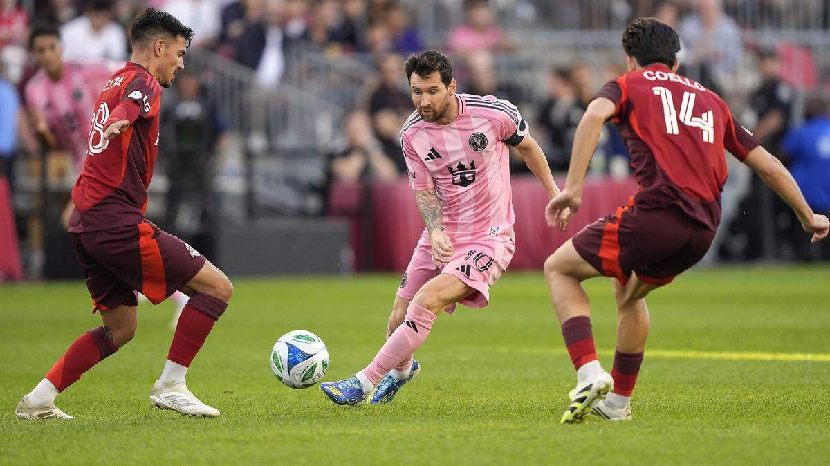 El astro del Inter Miami Lionel Messi (centro) trata de pasar la marca de Raoul Petretta (izq.) y Alonso Coello, de Toronto FC, en el partido de la MLS celebrado el 27 de septiembre de 2025 en Toronto, Canadá