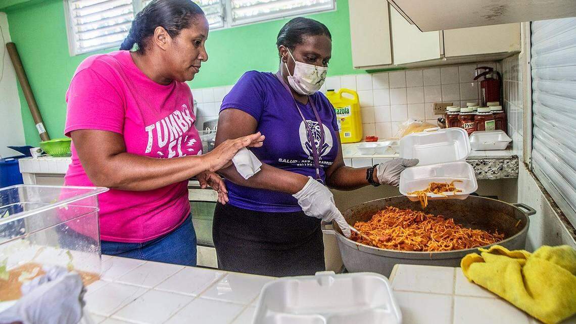 María Villegas, left, and Judith Edward prepare food to give to people in Loíza, Puerto Rico, for a previous storm that hit the island.PEDRO PORTAL pportal@miamiherald.com