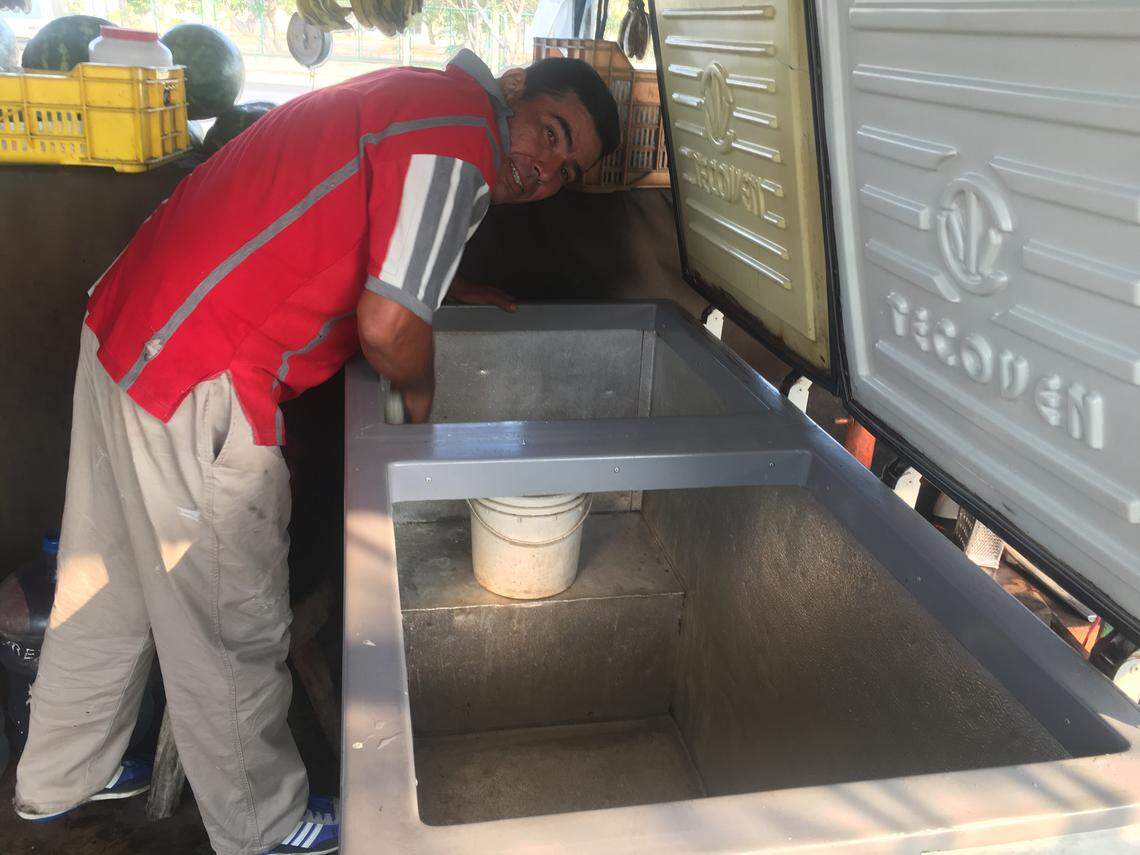 Alexander Villalobos limpia su nevera tras varios días de apagón.