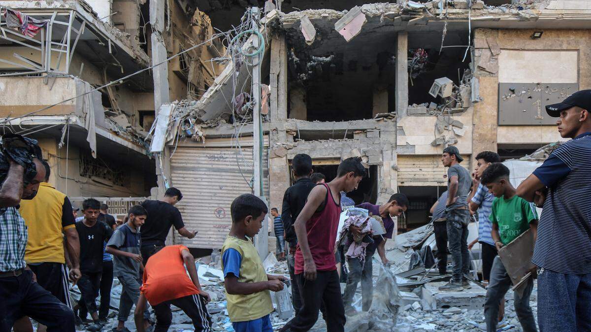 Una decena de palestinos se reúnen alrededor de un edificio destruido por un bombardeo israelí, el sábado 30 de agosto de 2025, en el oeste de la Ciudad de Gaza.