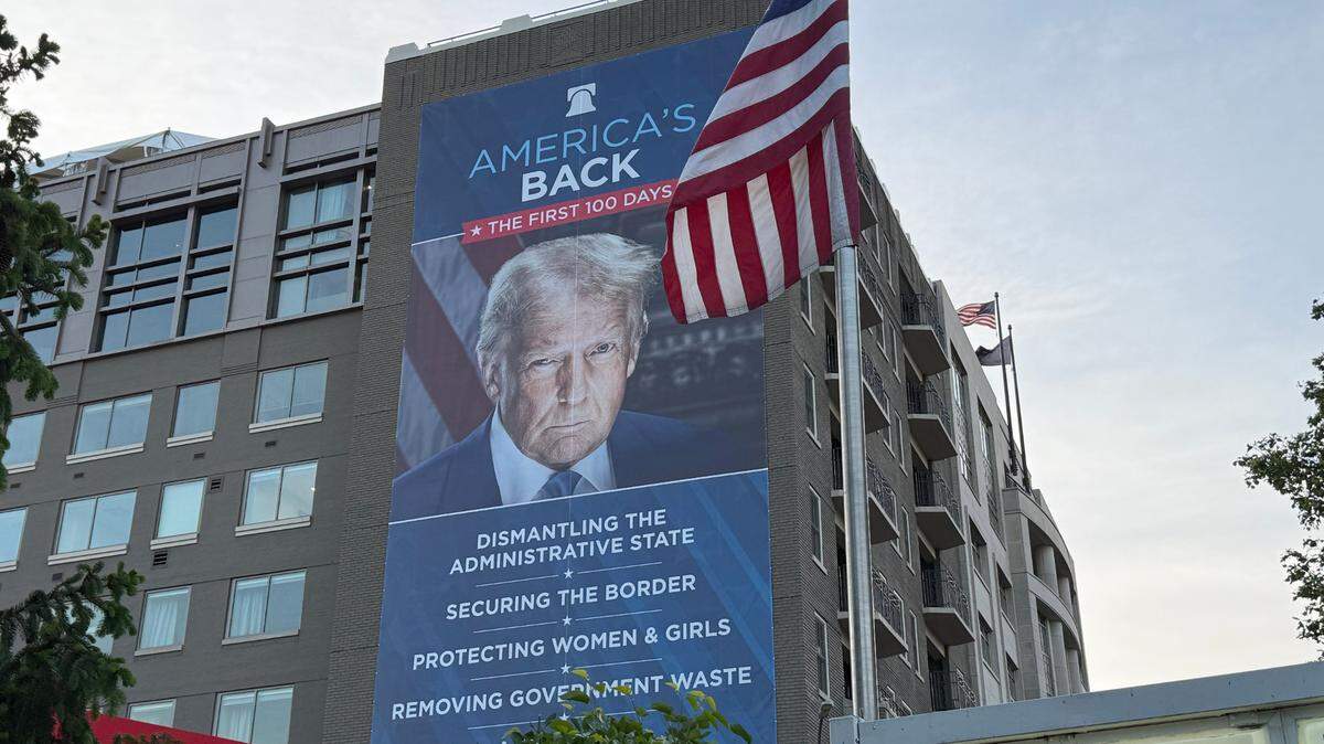 Un cartel del presidente estadounidense Donald Trump con el lema “America’s Back. The first 100 days” (“Estados Unidos ha vuelto. Los primeros 100 días”) cuelga en la pared de una casa en Capitol Hill, en Washington D. C. el 29 de abril de 2025.