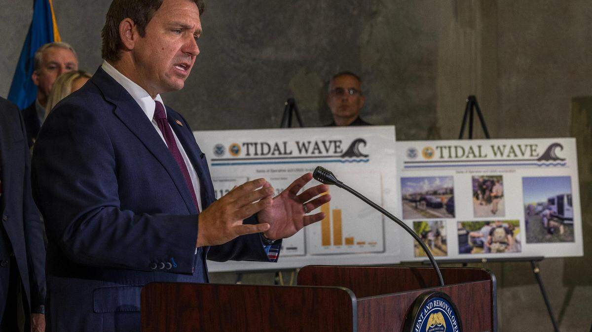 El gobernador Ron DeSantis habla junto a gráficos de arrestos en la Operación Tidal Wave durante una conferencia de prensa el jueves en la oficina de la Operación de Deportación y Control de Inmigración de ICE en Miramar.