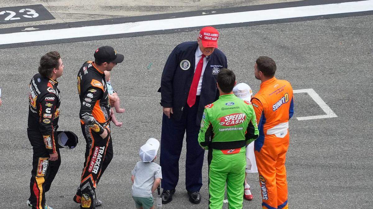 El presidente de Estados Unidos Donald Trump saluda a pilotos y sus familiares en el Daytona International Speedway antes del inicio de carrera Daytona 500 de la serie NASCAR, el 16 de febrero de 2025.