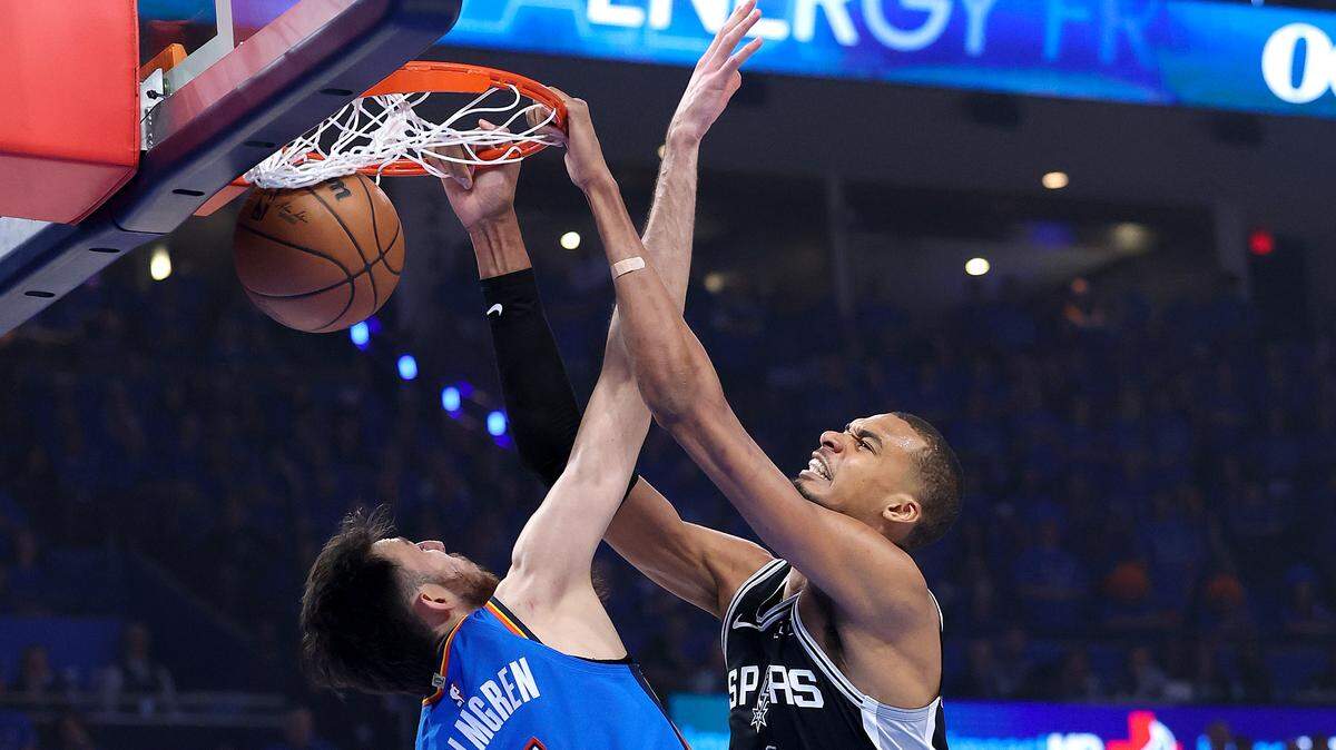 El astro de los Spurs de San Antonio Victor Wembanyama (der.), clava la pelota ante Chet Holmgren (#7), del Thunder, durante el primer cuarto del séptimo partido de las Finales de la Conferencia Oeste de la NBA, celebrado el 30 de mayo de 2026 en Oklahoma City.
