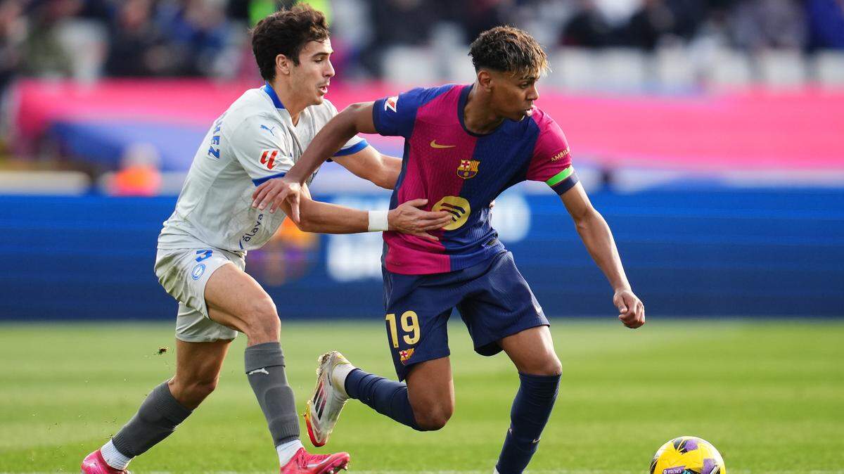 El jugador de Barcelona Lamine Yamal (der.) conduce el balón ante la marca de Manu Sánchez, del Deportivo Alavés, en el partido de la liga española celebrado el 2 de febrero de 2024 en Barcelona.