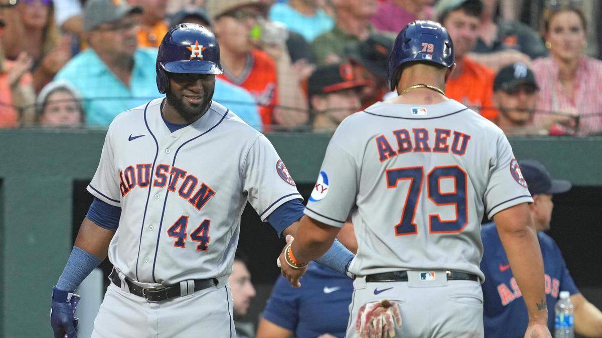 El primera base de los Astros José Abreu (der.) es felicitado por su compañero de equipo Yordan Álvarez tras anotar una carrera en el segundo inning del partido contra los Orioles, el 9 de agosto de 2023 en Baltimore.