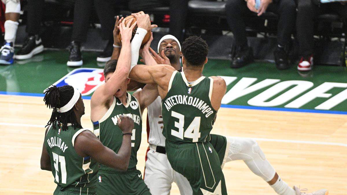 El jugador del Heat Jimmy Butler (centro) lucha por una pelota con Giannis Antetokounmpo, de los Bucks, en el quinto partido de la serie de playoffs de la NBA, celebrado el 26 de abril de 2023 en Milwaukee.