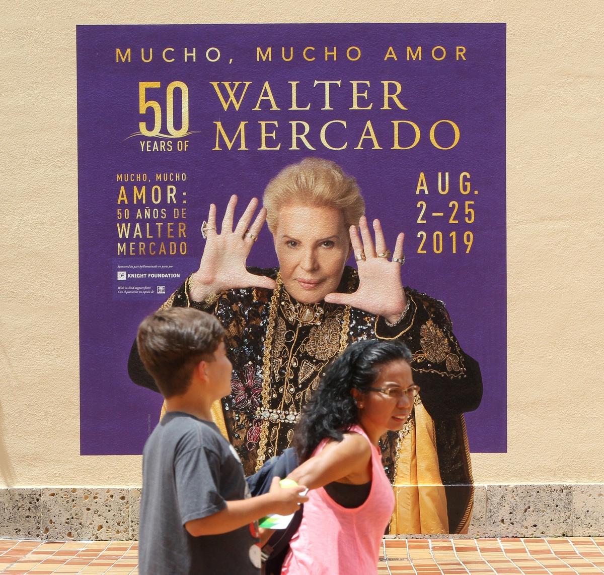 Dos personas pasan frente al mural con la imagen de Walter Mercado que abre la exposición dedicada a su vida y carrera que presenta en HistoryMiami Museum, desde el 2 al 25 de agosto.