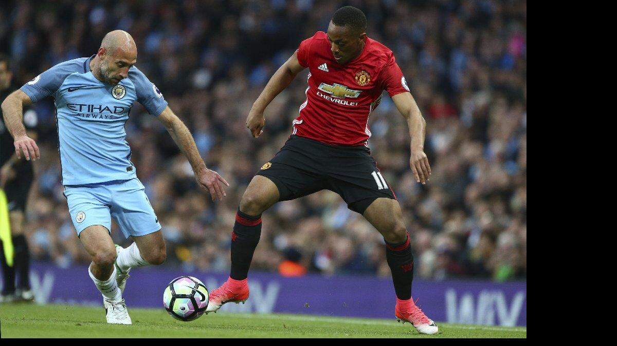 El jugador del Manchester City Pablo Zabaleta (izq.) disputa el balón con Anthony Martial, del United, en el partido efectuado el 27 de abril del 2017 en la liga Premier inglesa.