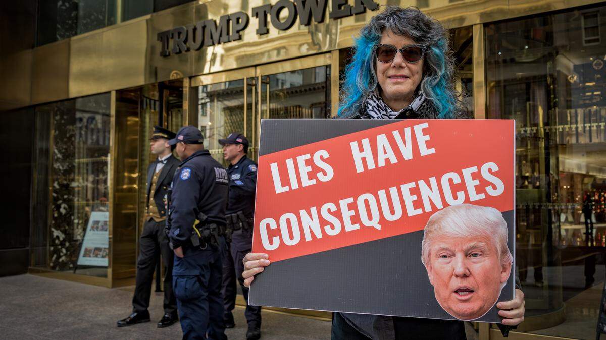 Una mujer sostiene una pancarta de protesta contra Donald Trump que dice “Las mentiras tienen consecuencias”, frente a la Torre Trump en Nueva York, el miércoles 13 de marzo de 2024.