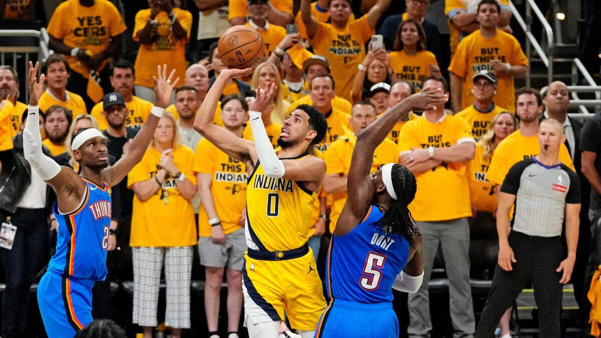 El jugador de los Pacers Tyrese Haliburton tira al aro ante la marca de Shai Gilgeous-Alexander (izq.) y  Luguentz Dort, del Thunder de Oklahoma City, en el tercer partido de las Finales de la NBA celebrado el 11 de junio de 2025 en Indianápolis.