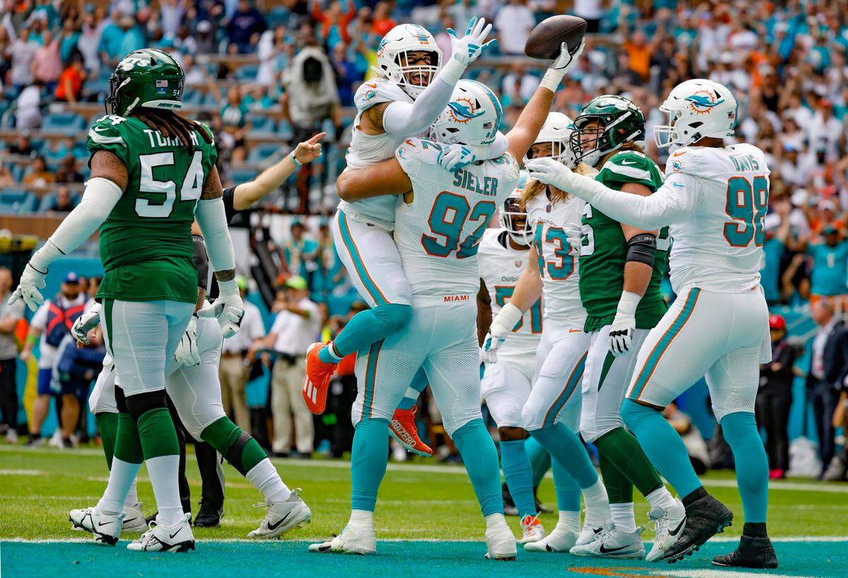El linebacker de los Dolphins Duke Riley (45) celebra con Zach Sieler (92) luego de que el defensive tackle recuperara un balón perdido en el partido ante los Jets de New York, efectuado el 17 de diciembre de 2023 en Miami Gardens, Florida.