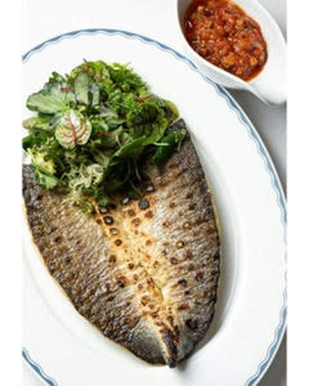 Uno de los platillos favoritos de The Surf Club, la lubina europea servida con salsa Livornesa.