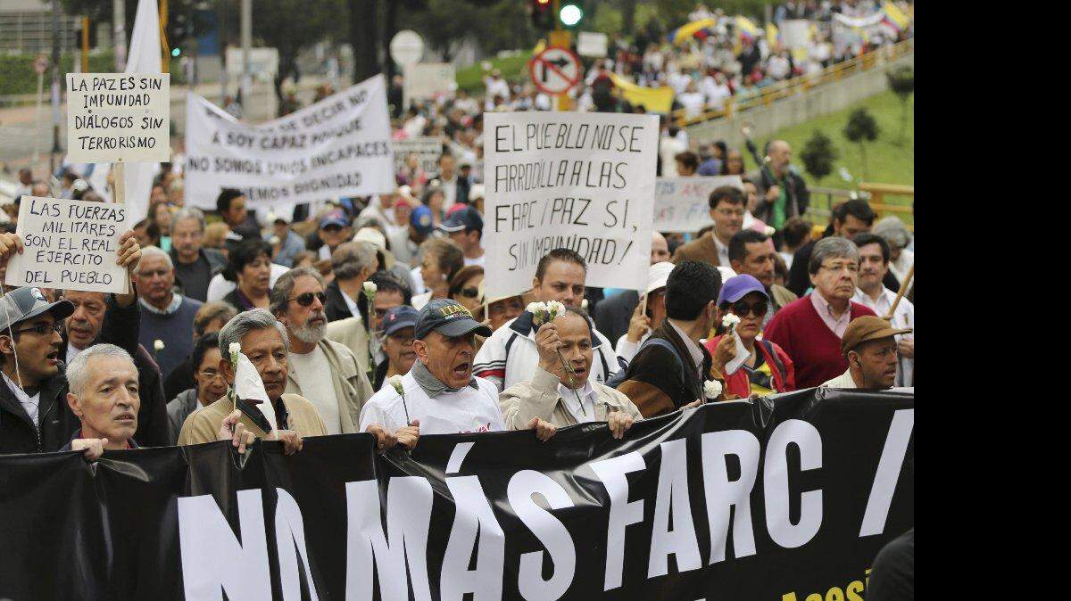 Al menos 5.000 personas marchaban el sábado 13 de diciembre de 2014 por las calles del centro de Bogotá para protestar contra la impunidad que según ellas habrá en el proceso de paz entre el gobierno y la guerrilla de las FARC.