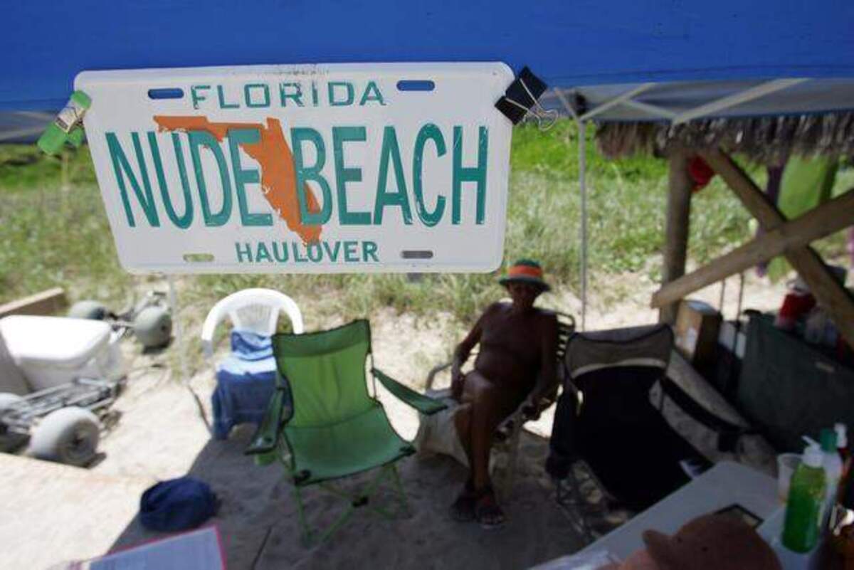 Un hombre se sienta en el puesto de comida en un tramo de la playa de Haulover, donde se permite el nudismo.