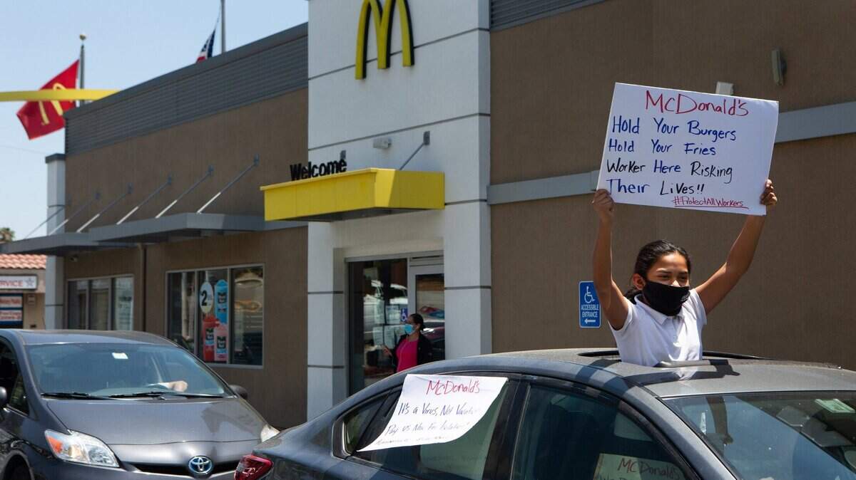 Una protesta apoya a trabajadores de McDonald’s en una ventanilla de servicio rápido en Monterey Park, California, el 20 de mayo. Seis sucursales de McDonald’s fueron mencionadas en una investigación de violación de los derechos de los trabajadores a tomar días pagos por el COVID-19.