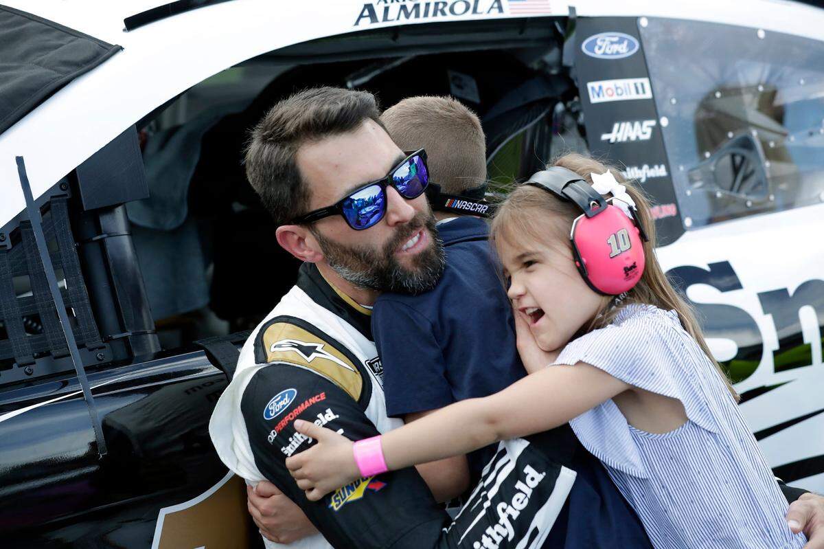 Aric Almirola abraza a sus hijos Alex (centro) y Abby (der.) antes de subirse a su auto para la carrera de autos NASCAR Daytona 500 en el Daytona International Speedway, el 16 de febrero de 2020 en Daytona Beach, Florida.