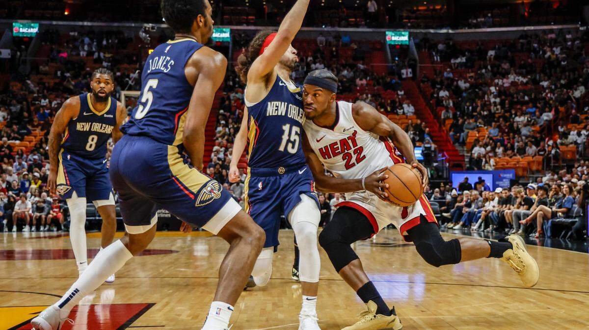 El delantero del Miami Heat Jimmy Butler (22) conduce el balón mientras el guardia de los New Orleans Pelicans, José Alvarado (15), defiende en la primera mitad en el Kaseya Center en Miami, Florida, el viernes 22 de marzo de 2024.