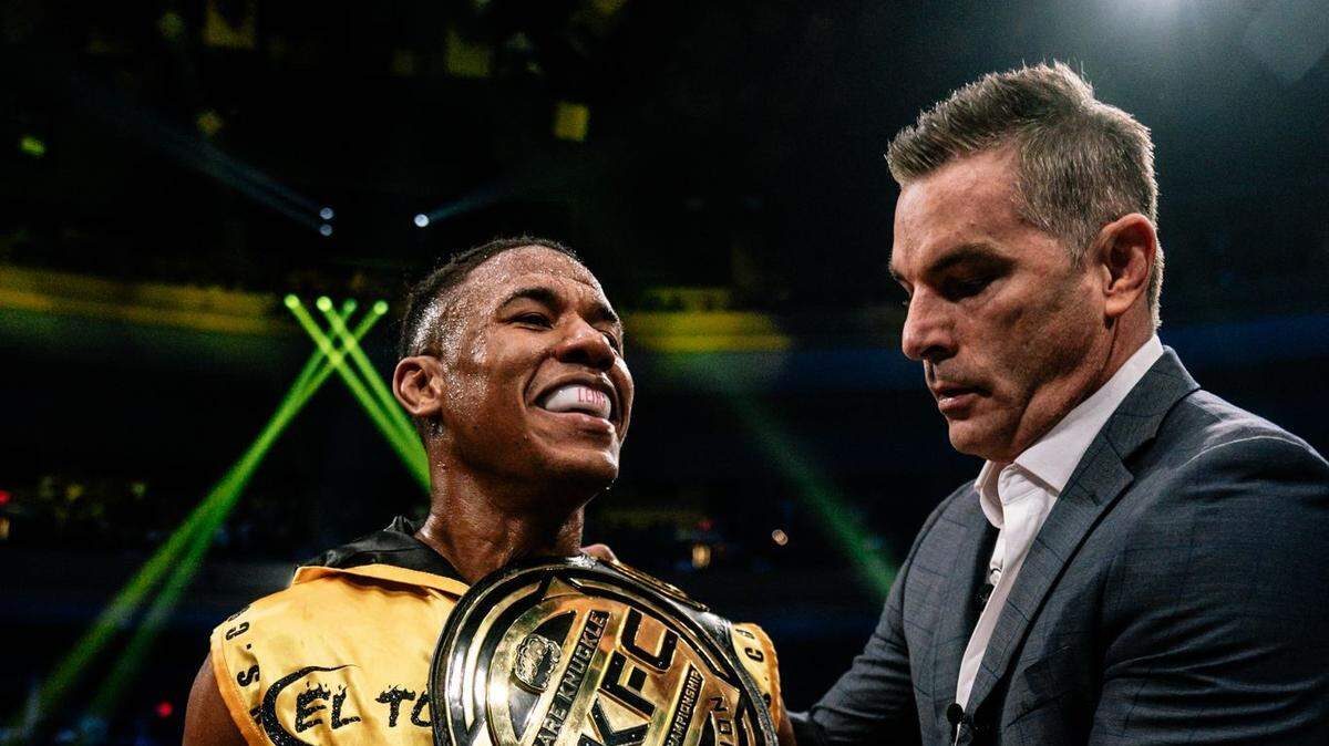 Alberto Blas recibe su faja de campeón de las 135 libras de parte del presidente de Bare Knuckle Fighting Championship David Feldman.