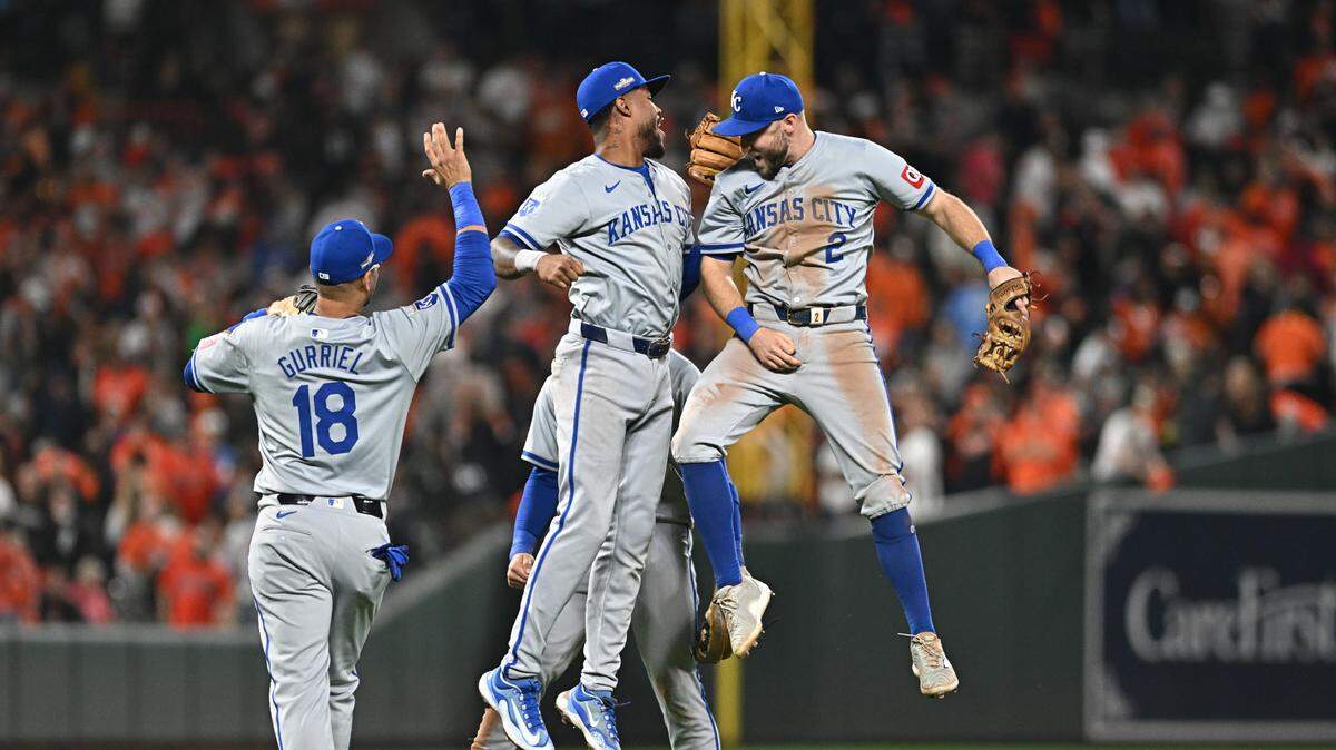 Yuli Gurriel (izq.) festeja con Garrett Hampson (der.) y Maikel García tras la victoria de los Reales de Kansas City ante los Orioles, en el partido de la Ronda de Comodines celebrado el 2 de octubre de 2024 en Baltimore.