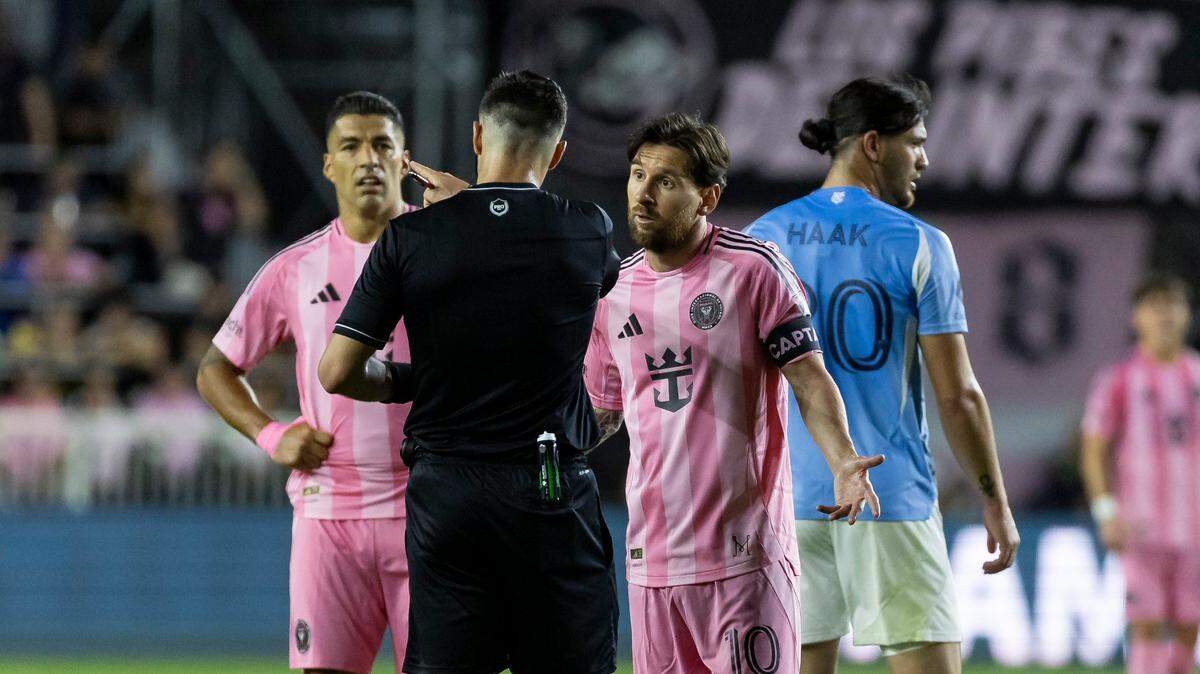 Los delanteros del Inter Miami Lionel Messi (der.) y Luis Suárez conversan con el árbitro del partido ante el New York City, celebrado el 22 de febrero de 2025 en el Chase Stadium en Fort Lauderdale, Florida.