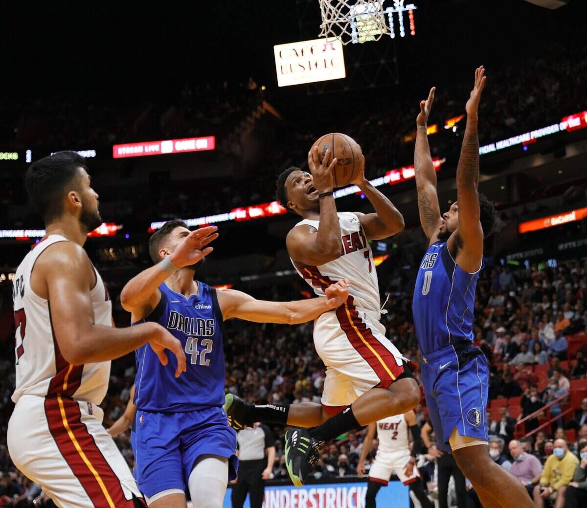 El jugador del Heat Kyle Lowry entra al aro ante la marca de Sterling Brown (0) y Maxi Kleber, de los Mavericks de Dallas, en el partido celebrado el 15 de febrero de 2022 en Miami.